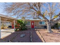 House exterior with red door, carport, and mature tree landscaping at 2828 Richfield Blvd, Las Vegas, NV 89102