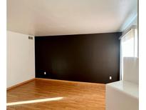 Bright living room featuring hardwood floors, neutral walls, and a large window for natural light at 698 S Racetrack Rd # 711, Henderson, NV 89015