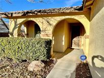 Inviting front porch with arched entryway, well-manicured shrubs, and a paved walkway at 4700 E Brolio Ct, Pahrump, NV 89061