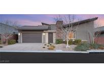 Modern home exterior with gray siding, two-car garage, and landscaped front yard at 6056 Willow Rock St, Las Vegas, NV 89135