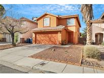 Two-story house with orange exterior, double garage, and landscaping at 6921 Wineberry Dr, Las Vegas, NV 89119