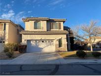 Two-story house with attached garage and landscaped yard at 10332 Splendor Ridge Ave, Las Vegas, NV 89135