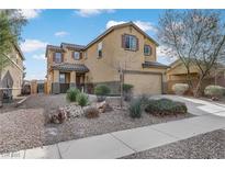 Two story house with tan siding, brown roof, and landscaped yard at 165 Arrow Point Ln, Henderson, NV 89011