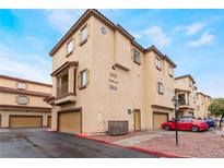 Tan colored, two-story building with multiple units and garages at 5925 Palmilla St # 12, North Las Vegas, NV 89031