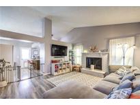 Cozy living room with a fireplace, plush sofa, and open access to the kitchen area at 914 Clipper Dr, Henderson, NV 89015