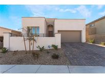 Single-story home with modern facade, two-car garage, and landscaped front yard at 11707 Hatchling Ave, Las Vegas, NV 89138