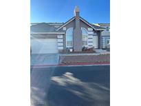 Charming single-Gathering home featuring a two-car garage, chimney, and desert landscaping at 121 Golf Course St, Las Vegas, NV 89145