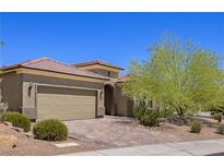 Single-story home with tan exterior, landscaped yard, and a two-car garage at 1359 Skylight Way, Mesquite, NV 89034