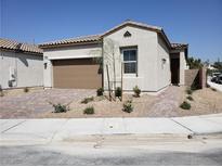 Single-story home with a two-car garage and landscaped front yard at 1706 Pondering Ave, North Las Vegas, NV 89031