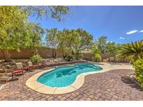 Inviting kidney-shaped pool with brick patio and seating area at 3 Chatmoss Rd, Henderson, NV 89052