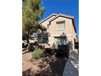 Tan two-story house with a red tile roof, landscaping, and a gated entrance at 3025 Sunrise Bay Ave, North Las Vegas, NV 89031