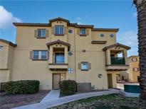 Tan three-story townhome with balcony and landscaping at 5960 Palmilla St # 3, North Las Vegas, NV 89031