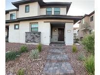 Two-story home with stone accents and a paved walkway at 717 Pickled Pepper Pl, Henderson, NV 89011