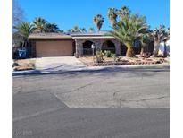 Single story home with a two car garage and mature landscaping at 3011 Liberty Cir, Las Vegas, NV 89121