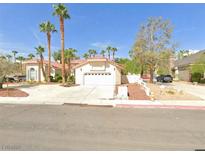 Single-story house with red tile roof, two-car garage, and mature landscaping at 2131 Americas Cup Cir, Las Vegas, NV 89117