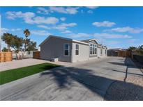 Single-story home with gray siding, a long driveway, and a landscaped yard at 3446 Cactus Springs Dr, Las Vegas, NV 89115