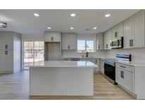 Modern kitchen with island, stainless steel appliances, and light gray cabinets at 4962 E Baltimore Ave, Las Vegas, NV 89104