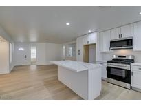 Modern kitchen with white cabinets, quartz countertops, and stainless steel appliances at 8712 Majestic Pine Ave, Las Vegas, NV 89143