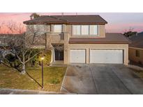 Two-story house with three-car garage, balcony, and landscaping at 8728 Burning Hide Ave, Las Vegas, NV 89143