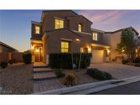 Two-story house with a landscaped front yard, brick walkway, and two-car garage at dusk at 8853 Sherborne Gate Ave, Las Vegas, NV 89148