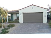 Single-story home featuring a brick driveway, a two-car garage and desert landscaping at 9577 Among Ln, Las Vegas, NV 89143