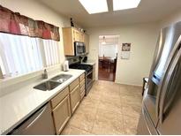 Bright kitchen features stainless steel appliances and light wood cabinets at 10065 Hemet Dr, Las Vegas, NV 89134