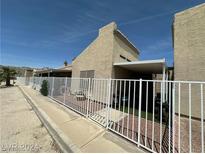 Back exterior view of single story home with covered patio and fenced yard at 2235 High Dunes Ln, Laughlin, NV 89029