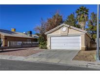 House exterior featuring a two-car garage and desert landscaping at 5954 Wabusca Way, Las Vegas, NV 89142