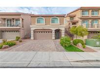 Two-story house with tan exterior, arched garage door, and landscaped front yard at 6034 Pirates Delight Ave, Las Vegas, NV 89139