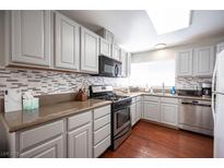 Modern kitchen with granite countertops, stainless steel appliances, and gray cabinets at 6575 Ellerhurst Dr, Las Vegas, NV 89103