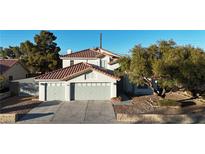 Two-story house with gray double garage doors and a landscaped yard at 1252 Little Sidnee Dr, Las Vegas, NV 89123