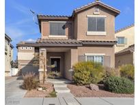Two-story house with light brown exterior, landscaping, and a two-car garage at 1320 Robbers Roost Ave, Henderson, NV 89012