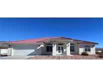 One-story house with red tile roof, white walls, and a two-car garage at 6181 Meadow Creek Ln, Pahrump, NV 89060