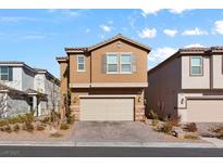 Two-story house with beige exterior, neutral garage door, and landscaped front yard at 6986 Bard Ave, Las Vegas, NV 89113