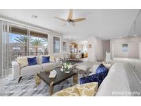 Bright living room with a ceiling fan, neutral walls, stylish furniture, and balcony access with a view at 805 Dana Hills Ct # 104, Las Vegas, NV 89134