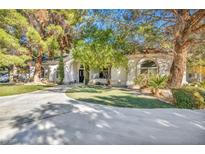 House exterior featuring a large driveway and mature trees at 8170 W Red Coach Ave, Las Vegas, NV 89129