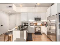 Modern kitchen features white cabinetry, stainless steel appliances, and granite countertops at 353 E Bonneville Ave # 632, Las Vegas, NV 89101
