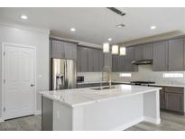 Modern kitchen with gray cabinets, marble countertops, and stainless steel appliances at 4119 Amberdale Ave, North Las Vegas, NV 89031