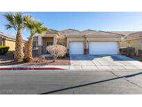 Single-story house with two-car garage, landscaping, and palm trees at 4624 Mission Cantina St, North Las Vegas, NV 89081