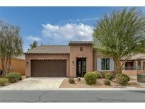 Single-story home with a tile roof, brown stucco, desert landscaping, and a two-car garage at 5625 Galivan Vista St, North Las Vegas, NV 89081