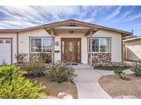 Inviting Ranch home features a charming front porch and well-manicured landscaping at 635 8Th St, Boulder City, NV 89005