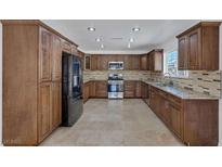 Spacious kitchen features granite countertops, stainless steel appliances, and ample cabinet space at 7220 Stormson Dr, Las Vegas, NV 89145