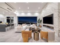 Modern living room featuring a marble fireplace and panoramic views of the city skyline at 1 Boulderback Dr, Henderson, NV 89012