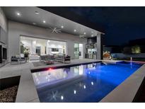 Stunning backyard featuring a modern pool, outdoor kitchen, and seamless indoor-outdoor living space at 1 Boulderback Dr, Henderson, NV 89012