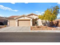 Single-story house with three-car garage, landscaping, and desert landscaping at 2134 Dillons Cove Dr, Laughlin, NV 89029
