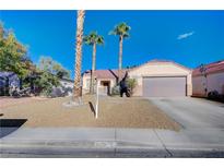 Single-story home with a two-car garage and desert landscaping at 6128 Casper Sands Ct, North Las Vegas, NV 89031