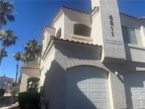 Spanish style condo building with attached garage and palm trees at 6811 San Ricardo Ave # 101, Las Vegas, NV 89146