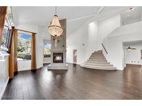 Spacious living room with hardwood floors, a large fireplace, and a stunning chandelier at 2114 Inverness Dr, Henderson, NV 89074