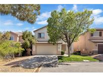 Two-story house with beige exterior, attached garage, and landscaped yard at 9893 Canyon Peak Dr, Las Vegas, NV 89147