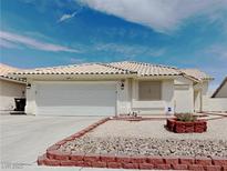 Single-story house with a two-car garage and landscaped front yard at 3002 W Gilmore Ave, North Las Vegas, NV 89032